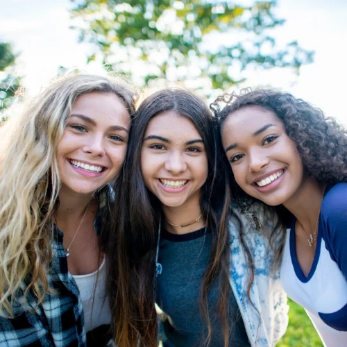 Tre ragazze sorridenti mostrano i risultati dei trattamenti ortodontici ricevuti nello studio dentistico della Dott.ssa Lorenzini a Firenze